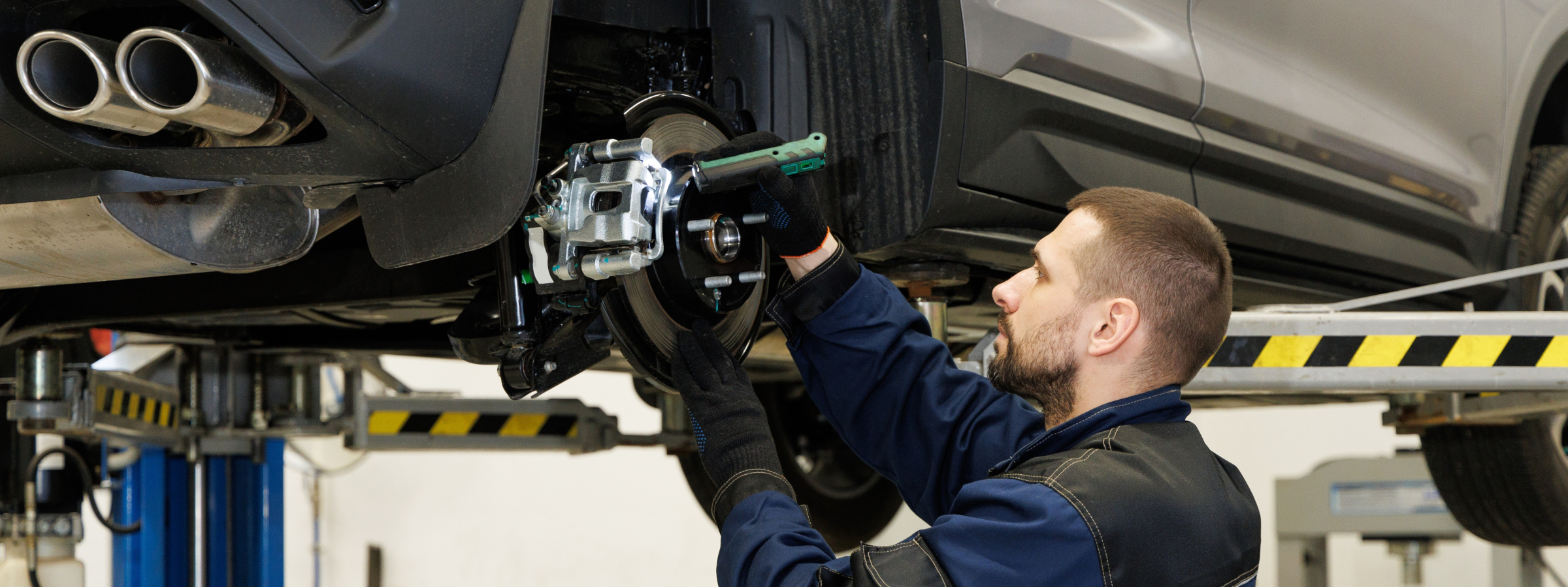 Mechanic servicing a vehicle, illustrating pre-owned car warranty coverage at TM Motors in Riverside, CA